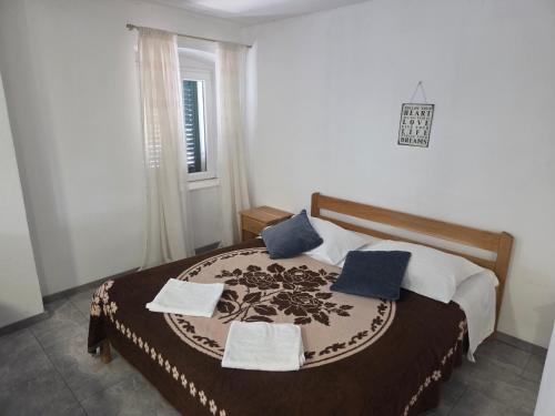 a bedroom with a bed with blue pillows and a window at Apartment Central in Šibenik