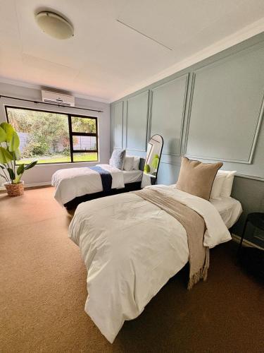 a bedroom with three beds and a window at 101 Marais Villa in Hartbeespoort