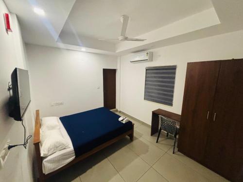 a bedroom with a bed and a desk in it at Mansori Residency in Cochin