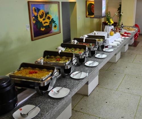 a buffet line with several trays of food at Hotel Faranda Express Puerta del Sol Porlamar in Porlamar