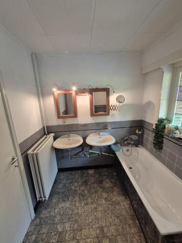 a bathroom with two sinks and a bath tub at Pré du Tour in Érezée