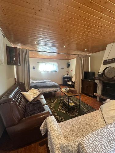 a living room with a leather couch and a table at Casa do Vale - Seixas in Caminha