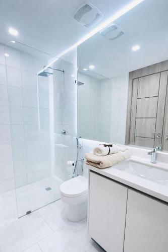 a white bathroom with a toilet and a sink at Zen Living Sky Suite in SamborondÃ³n
