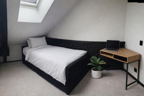 a small bedroom with a bed and a laptop on a desk at Studio 28 in Narvik
