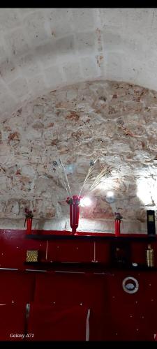 a red vase on a table in front of a ceiling at RODRIGUEZ Luxury Suite in Ostuni