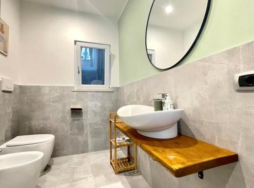 a bathroom with a sink and a toilet and a mirror at Anzio lighthouse terrace family-group friendly in Anzio