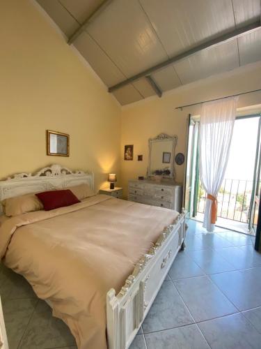 a bedroom with a large bed and a large window at Siciliana in Caronia