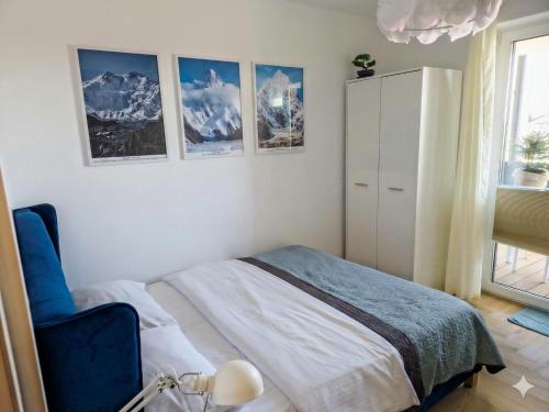 a bedroom with a bed and pictures on the wall at Apartament Rutkiewicz in Łańcut