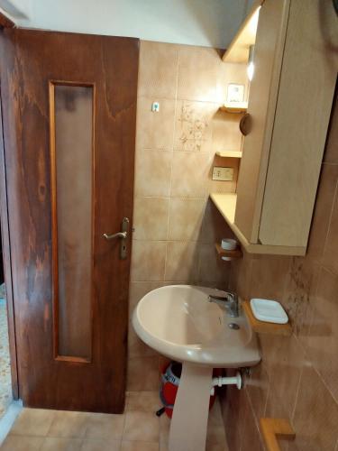 a bathroom with a sink and a wooden door at Casa Milda in Capoliveri