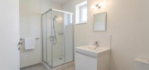 a white bathroom with a shower and a sink at Levent Hotel in Lara