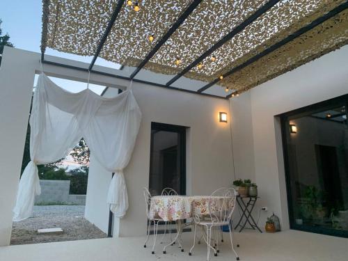 a patio with a table and a ceiling with lights at Chambre d'hôtes chez l' habitant Villa Bianca in Peaugres