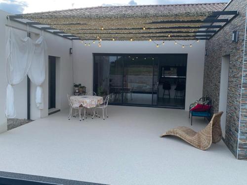 a patio with a table and chairs and a brick wall at Chambre d'hôtes chez l' habitant Villa Bianca in Peaugres