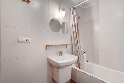 a white bathroom with a sink and a bath tub at Orio Playa in Orio