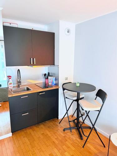 a small kitchen with a table and a sink at Apparemment agréable in Levallois-Perret