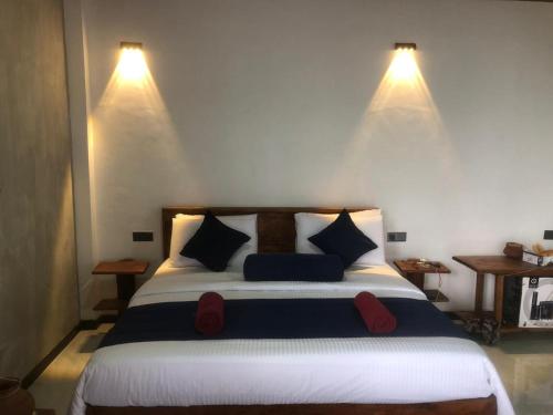 a bedroom with a bed with two lights on the wall at Ella 96TN Resort in Ella