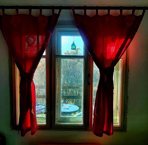 a window with red curtains and a view of the eiffel tower at Vila Eva in Međuvršje