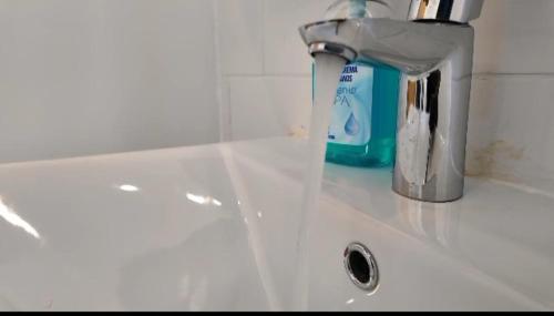 a white bathroom sink with a faucet on it at Gibbi's on the Beach in Elephant Island