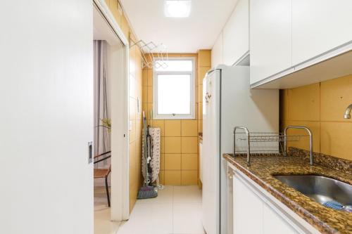 una cocina con fregadero y refrigerador en Apartamento Floripa, en Florianópolis
