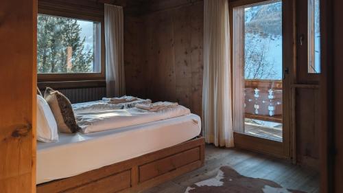a bedroom with a bed and a window in a room at Silva: The Alpine Chalet in Livigno
