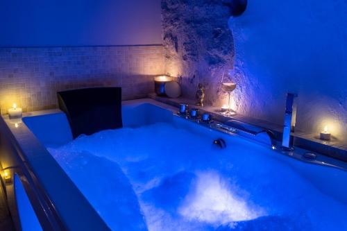 a bath tub with blue lighting in a room at La Sensuelle Suite with spa in Vendres