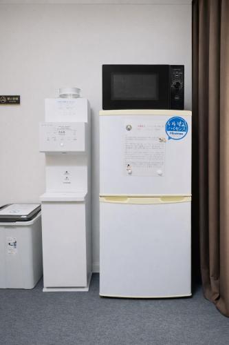 a microwave sitting on top of two refrigerators at Kyoto Toka inn京都東華inn in Kyoto