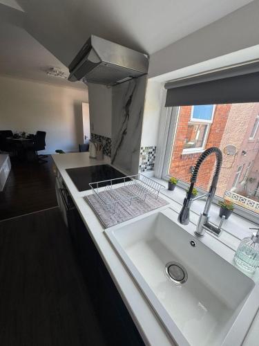 a kitchen with a sink and a window at Spacious 3BR Flat near Newcastle Centre in Saint Peters