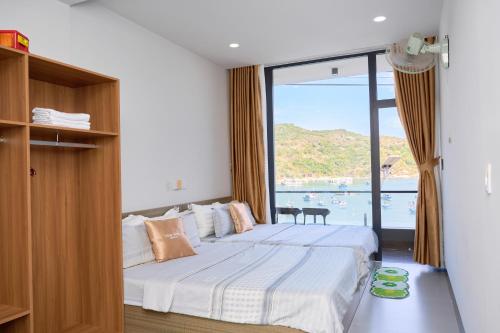 a bedroom with a bed with a large window at Hotel Vũng Găng in Vĩnh Hy