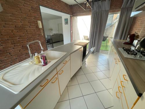 a kitchen with a sink and a brick wall at le Nid d Annie in Sancerre