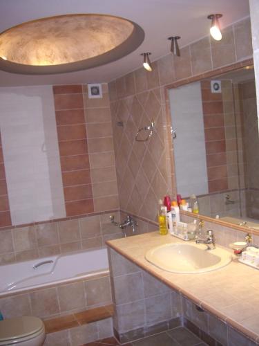 a bathroom with a sink and a toilet and a tub at Evelin Apartment in Portaria