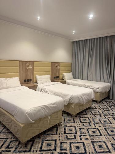 two beds in a hotel room with twothirdsessions at Dar Al-Areed in Medina