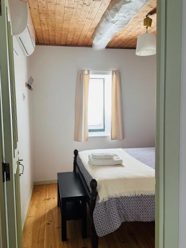 a bedroom with a bed and a window at Casa da Lurdinhas in Tabuaço