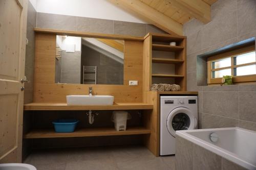 a bathroom with a sink and a washing machine at Niederhaushof in Santa Valpurga