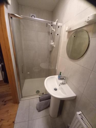 a bathroom with a shower and a sink and a mirror at Teach Sile in Kiltimagh