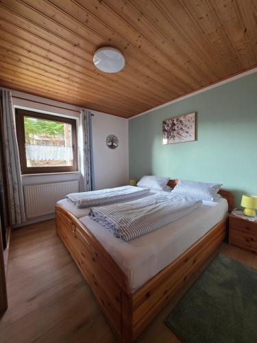 a bedroom with a large bed with a wooden ceiling at Kleines Glück am Bärenstein in Gößweinstein