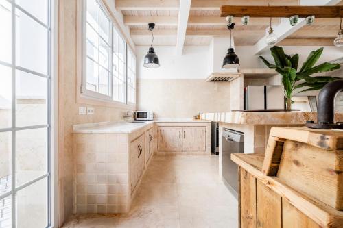 a kitchen with wooden cabinets and a large window at Cornise in El Rompido