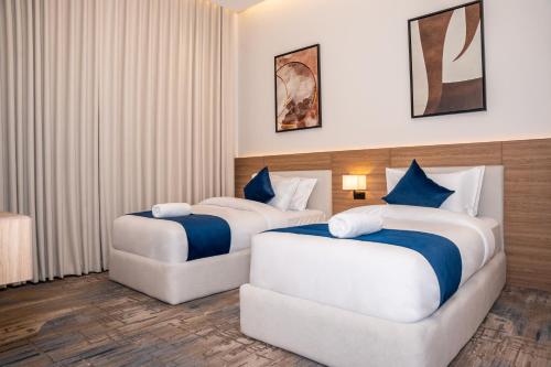 a hotel room with two beds and a chair at فندق ارجان بارك طويق 2 in Riyadh