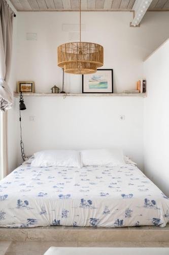 a bedroom with a bed and a chandelier at Cornise in El Rompido