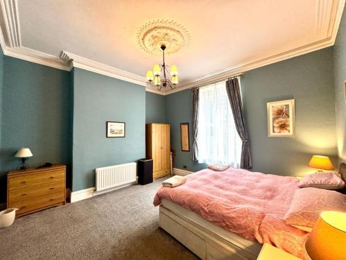 a bedroom with a pink bed and a chandelier at Regents Chambers in Bishop Auckland