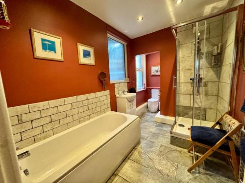 a bathroom with a tub and a shower and a toilet at Regents Chambers in Bishop Auckland