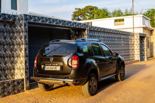 un SUV nero parcheggiato davanti a un garage di MARONE Villa a Nianing