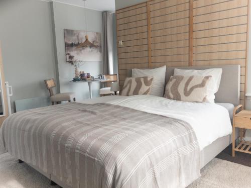 a bedroom with a large bed and a table at Villa Kakelbont in Leeuwarden