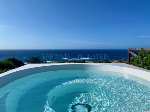 a swimming pool with the ocean in the background at Li Junchi in Costa Paradiso