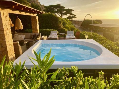 a hot tub in a yard with a patio at Li Junchi in Costa Paradiso