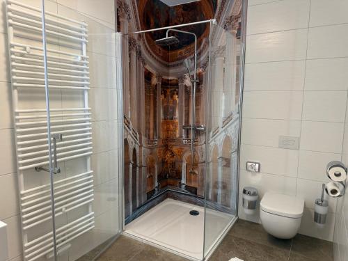 a glass shower in a bathroom with a toilet at Pension am Schloss in Meiningen