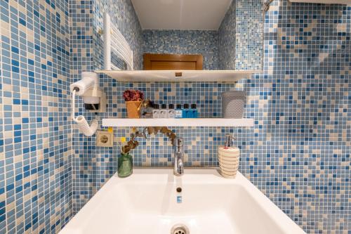 a bathroom with a sink and blue tiles at King Suite Hotel Beşiktaş in Istanbul