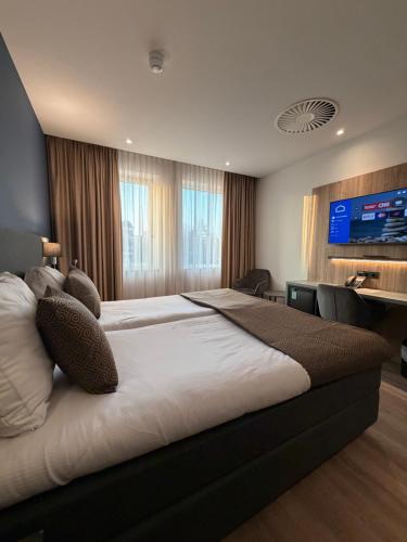 a bedroom with two beds and a flat screen tv at OZO Hotels Antares Amsterdam Schiphol Airport in Hoofddorp
