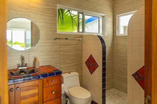 a bathroom with a toilet and a sink and a mirror at Casa Portofino in Chuburná