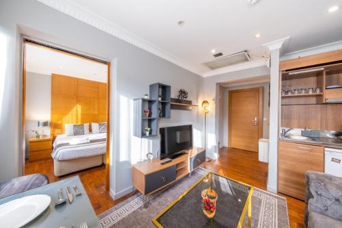 a living room with a couch and a television and a bed at King Suite Hotel Beşiktaş in Istanbul