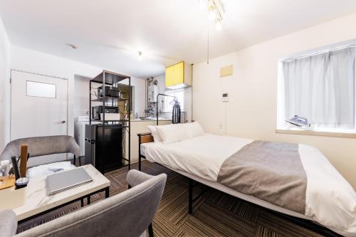 a bedroom with a bed and a desk with a laptop at Gran Form Kita 12-jo in Kita-sanjō