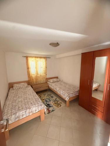 a bedroom with two beds and a window at Apartman Danilo i Filip in Risan